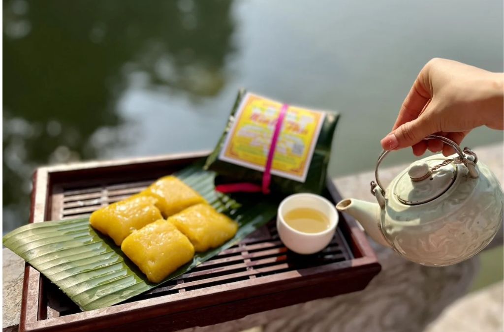  Bánh phu thê Đình Bảng màu vàng đặt trên lá cùng ấm và chén trà