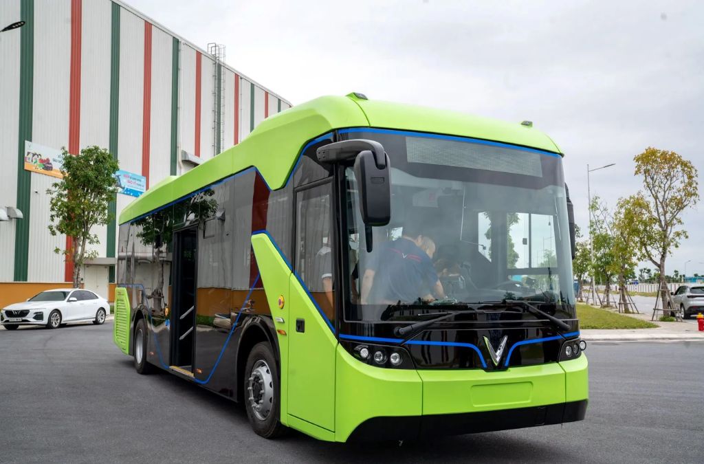 Xe buýt điện màu xanh lưu thông trên đường phố