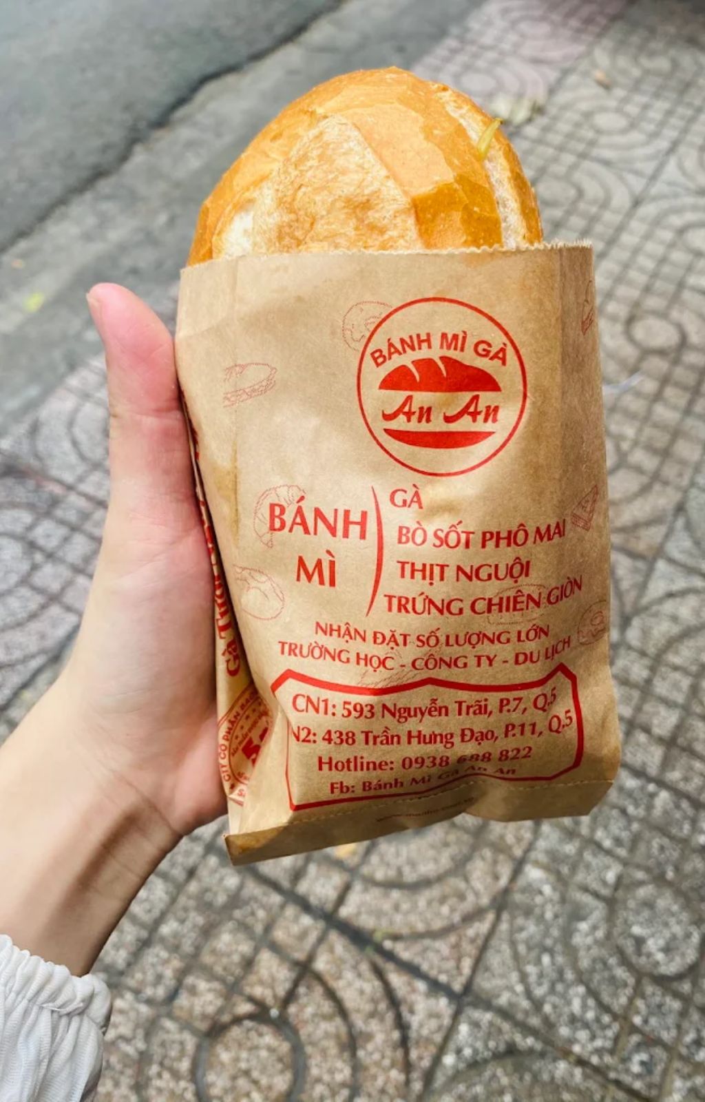 Ổ bánh mì gà An An đựng trong túi giấy của tiệm