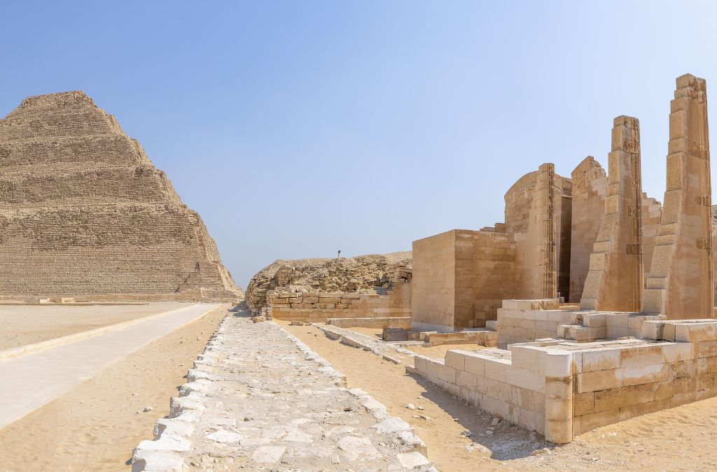 Toàn cảnh Kim tự tháp bậc thang Djoser tại Saqqara, Ai Cập, giữa sa mạc dưới bầu trời xanh.