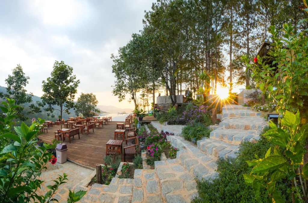 Khu vực bàn ghế ngoài trời tại Seven-T Coffee giữa rừng thông