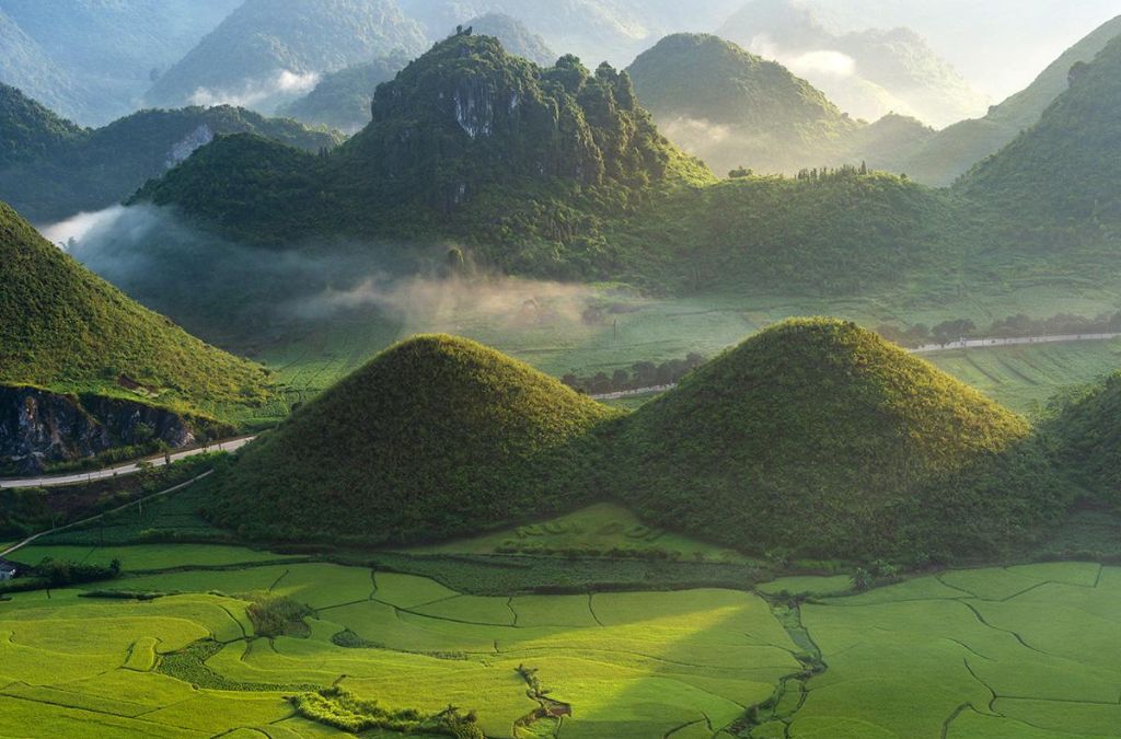 Núi Đôi Cô Tiên lúc bình minh với thung lũng và núi non trùng điệp.