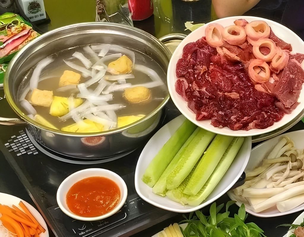 Bò nhúng dấm với thịt bò thái lát, rau xanh và bánh tráng.