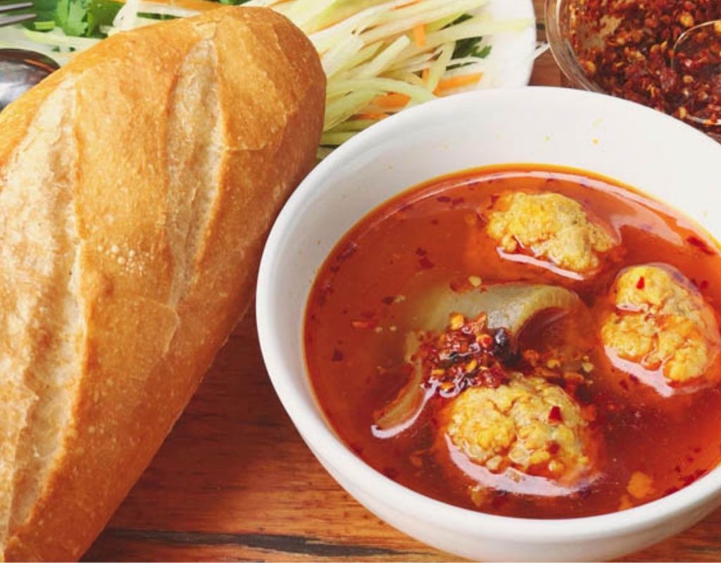 Bánh mì xíu mại chén với xíu mại, chả quế, da heo và bánh mì.