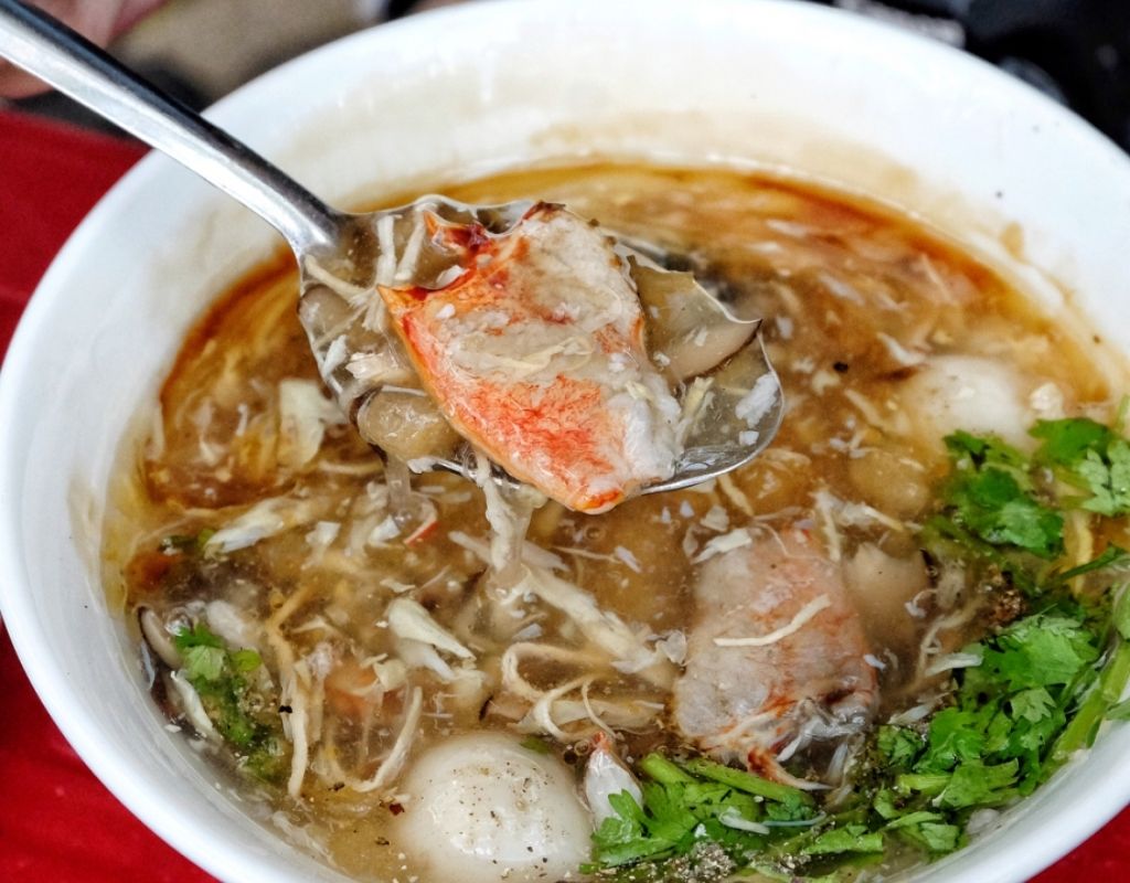 Chén súp cua nóng hổi với thịt cua, gà, nấm và trứng cút
