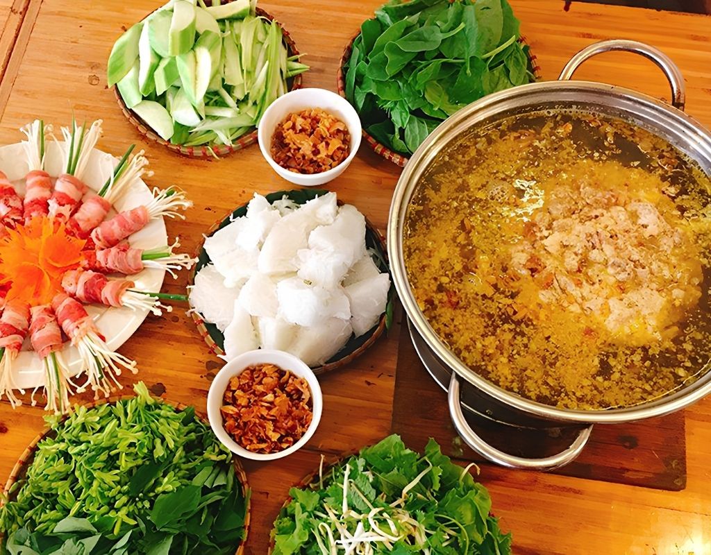 Nồi lẩu riêu cua đồng sườn sụn với riêu cua, sườn, bắp bò và rau tươi.