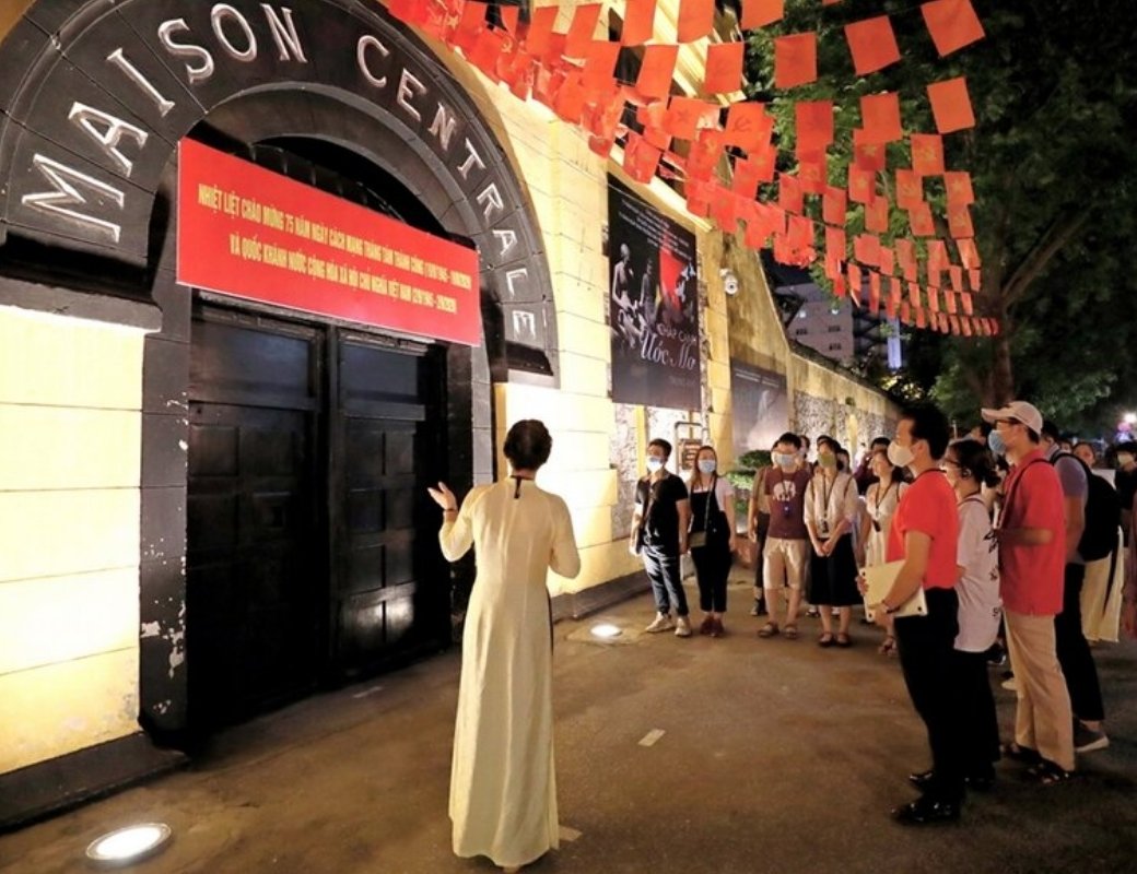 Người hướng dẫn dẫn đoàn khách tham quan Hỏa Lò về đêm.