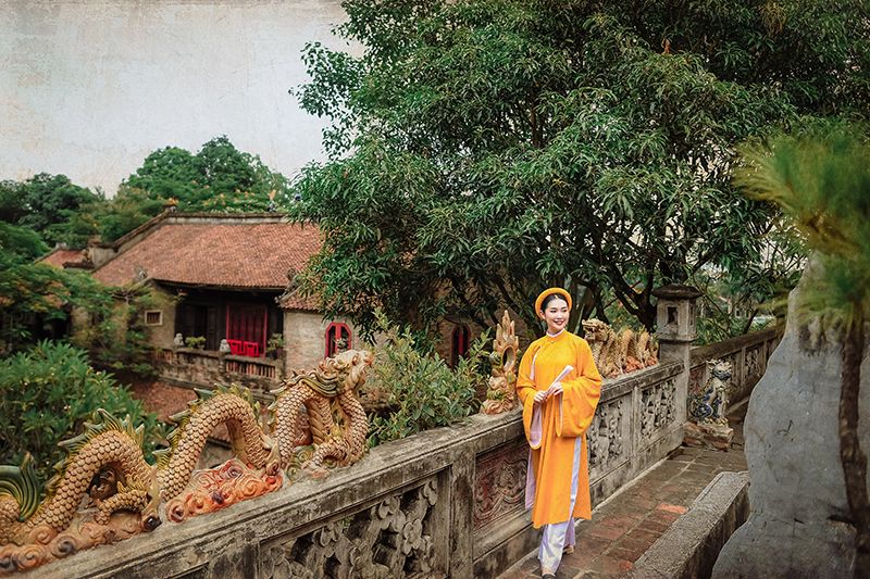 Không gian Việt Phủ Thành Chương Hà Nội với lan can đá chạm khắc hình rồng, nhà cổ mái ngói và cây xanh.
