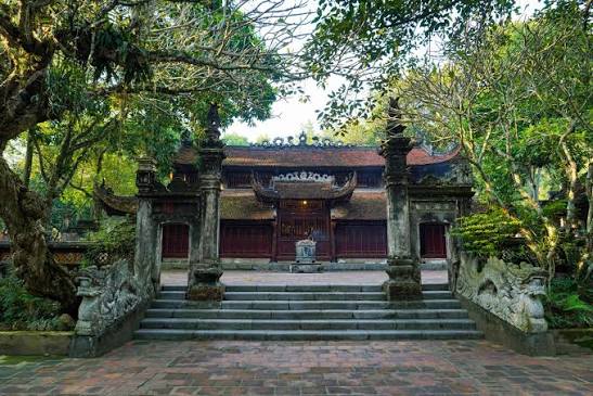 Đền Sóc Hà Nội với kiến trúc mái ngói cổ kính, bậc thang đá chạm khắc hình rồng và không gian cây xanh bao quanh.