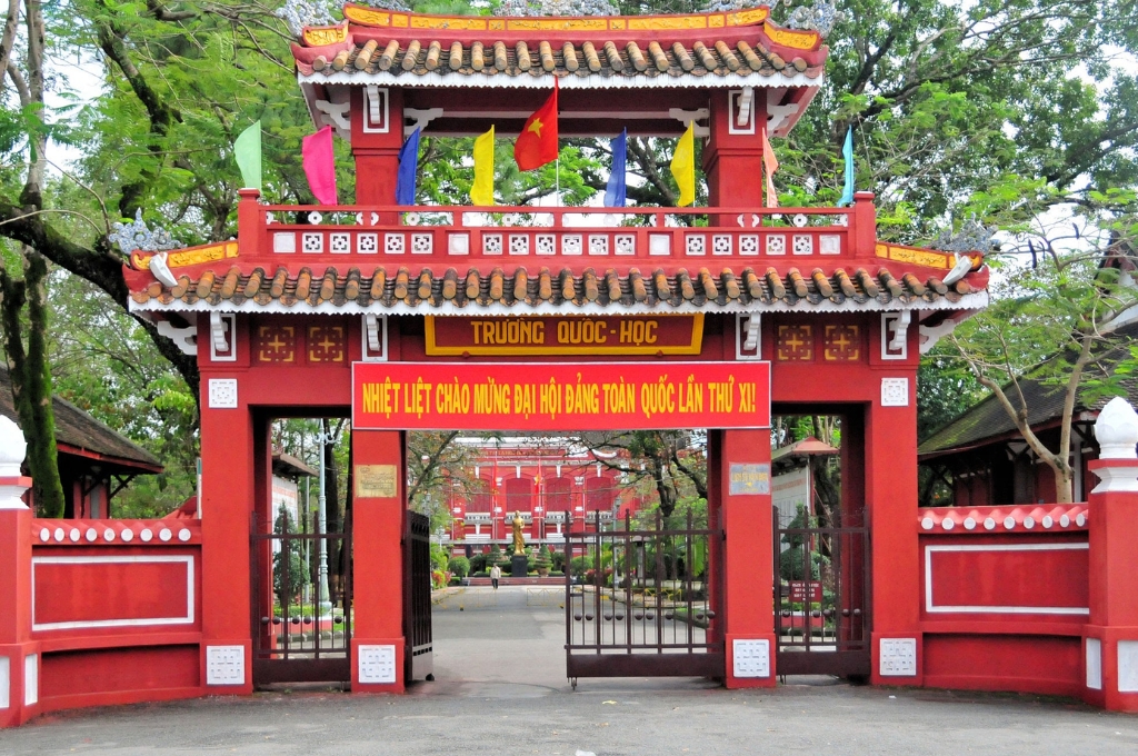 Cổng chính và dãy nhà kiến trúc Pháp sơn màu đỏ sẫm đặc trưng của Trường Quốc Học Huế