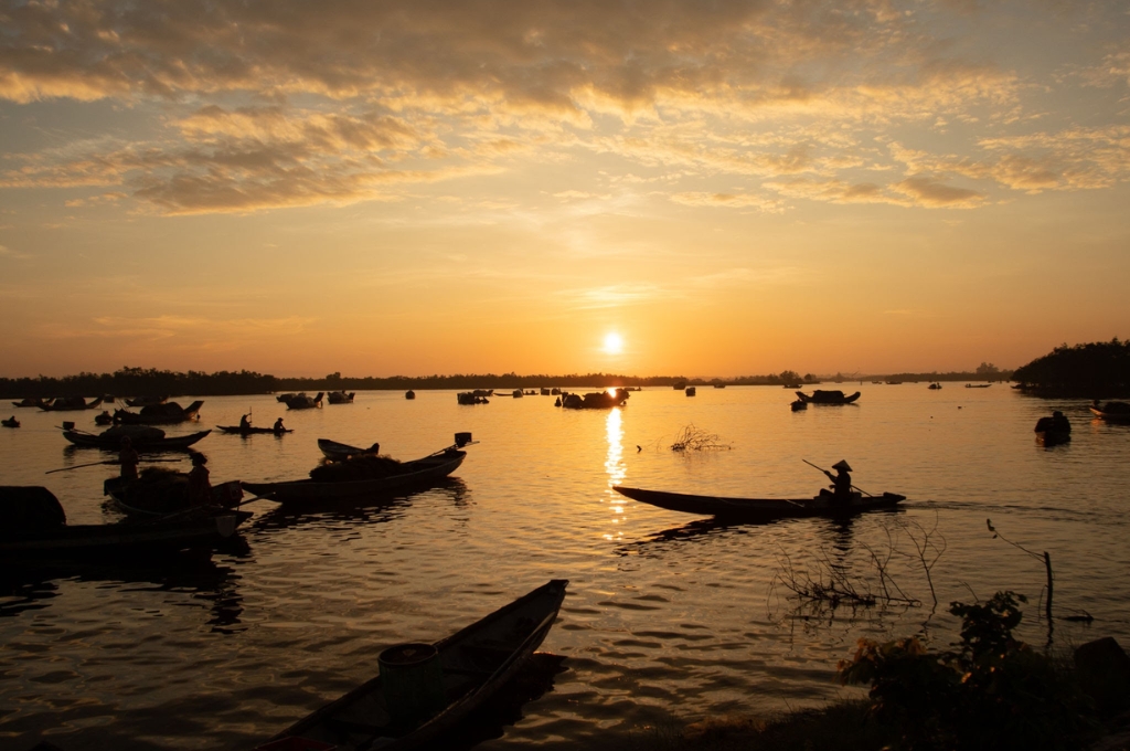 Khung cảnh hoàng hôn rực rỡ trên mặt nước mênh mông cùng thuyền ngư dân tại Phá Tam Giang Huế