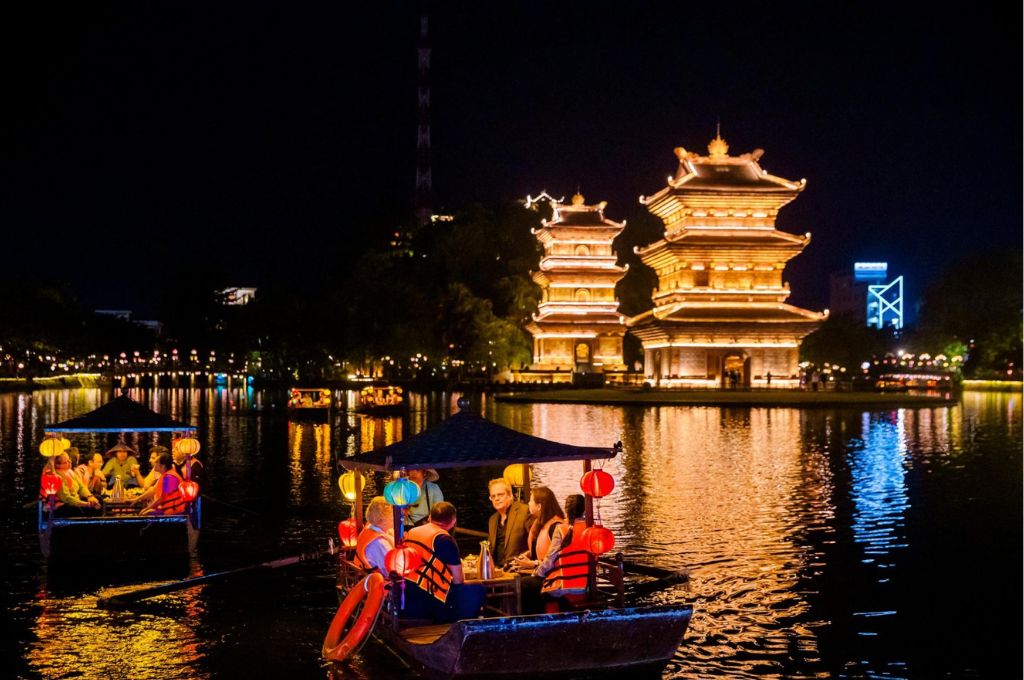 Phố cổ Hoa Lư Ninh Bình về đêm với thuyền trên hồ Kỳ Lân và các tòa tháp lên đèn