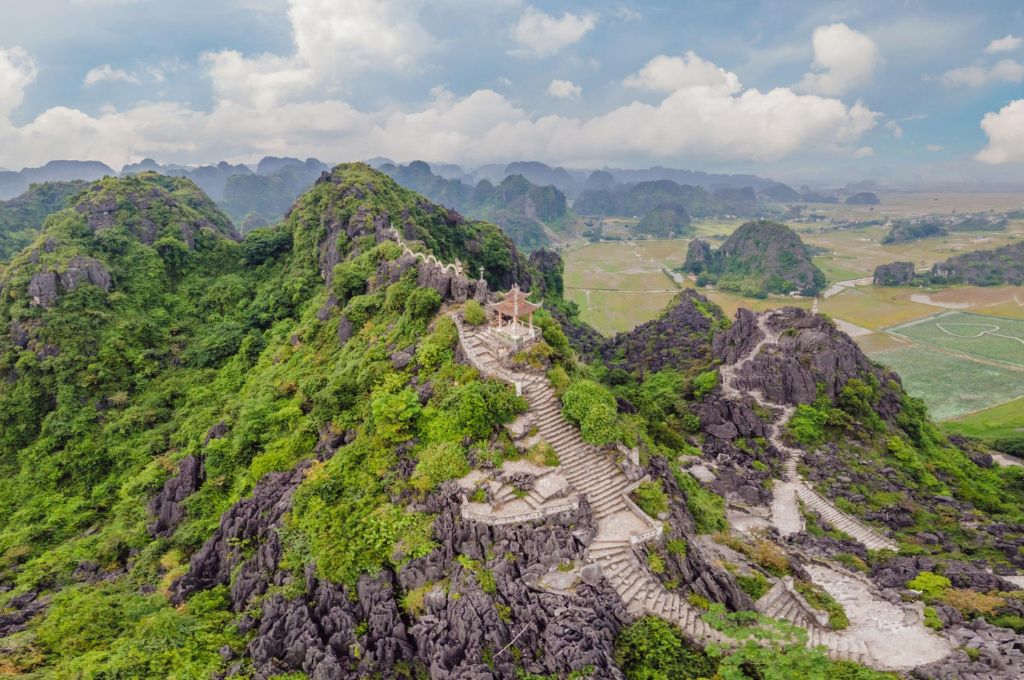 Đường bậc đá lên đỉnh Ngọa Long tại Hang Múa nhìn xuống núi đá vôi và đồng ruộng Ninh Bình
