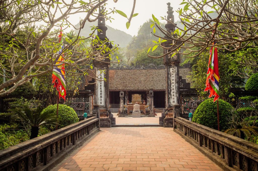 Lối vào đền cổ tại Cố đô Hoa Lư Ninh Bình với cờ hội và kiến trúc truyền thống 