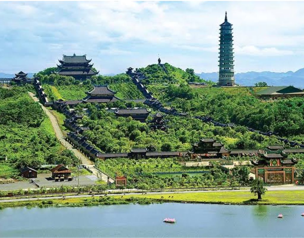 Quần thể danh thắng Tràng An với núi đá vôi, dòng nước xanh và thuyền nan tham quan.