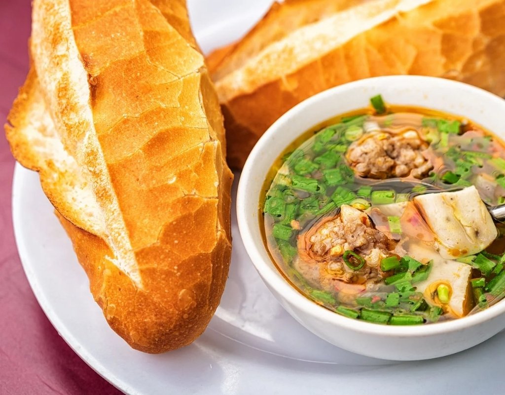 Bánh mì xíu mại chén Đà Lạt với viên xíu mại, chả quế, da heo và bánh mì giòn ăn kèm.