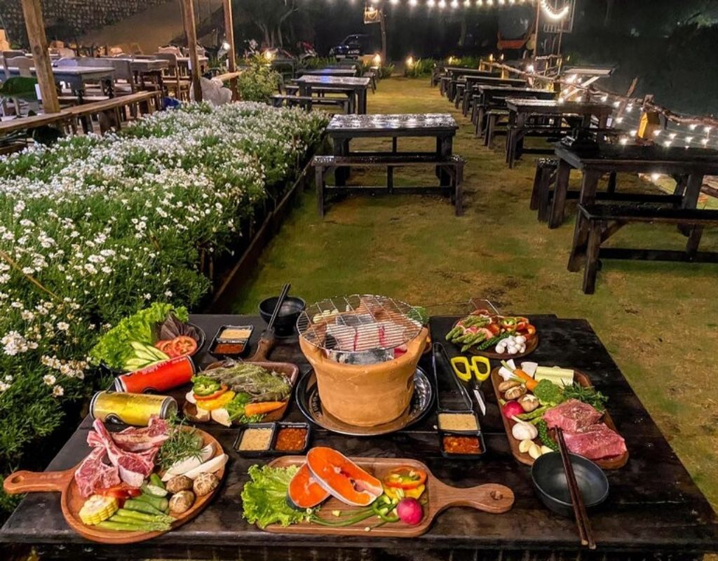 Các món thịt và rau củ nướng trên bếp than hồng, phía xa là thung lũng và đồi núi Đà Lạt.