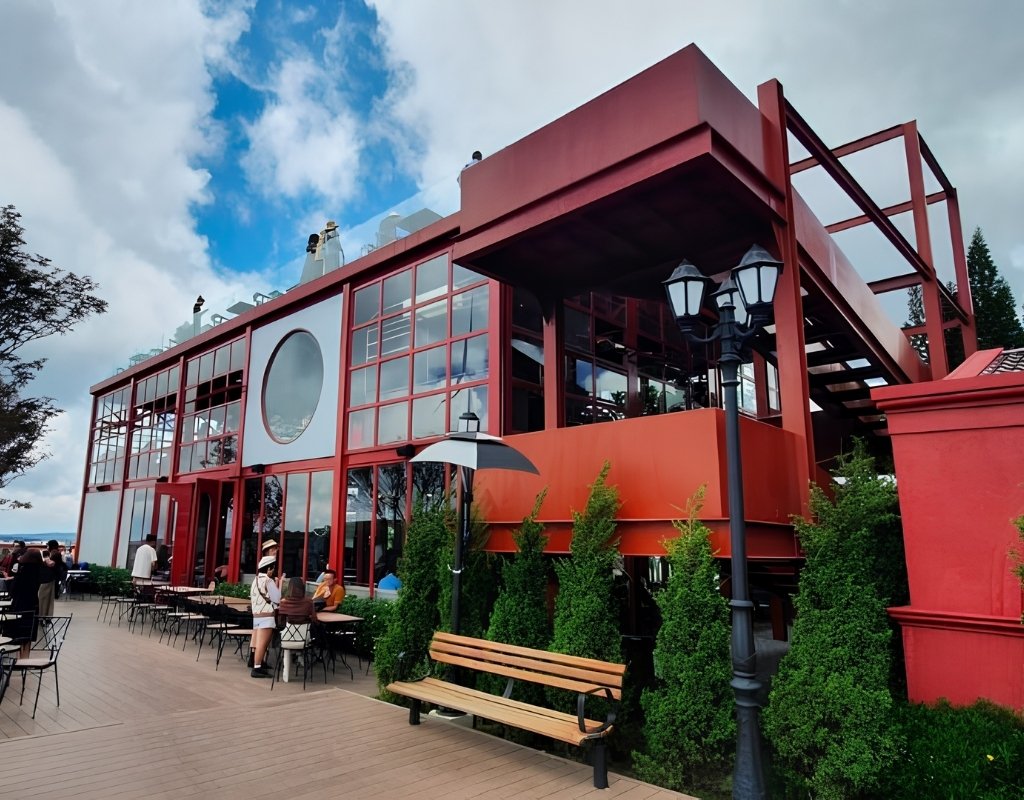 Cầu Đất Farm Cafe giữa đồi chè Cầu Đất với thiết kế container kính, bao quanh là những luống chè xanh trải dài.