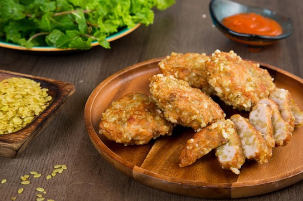 Chả cốm Hà Nội chiên vàng ăn kèm rau xanh và tương ớt.