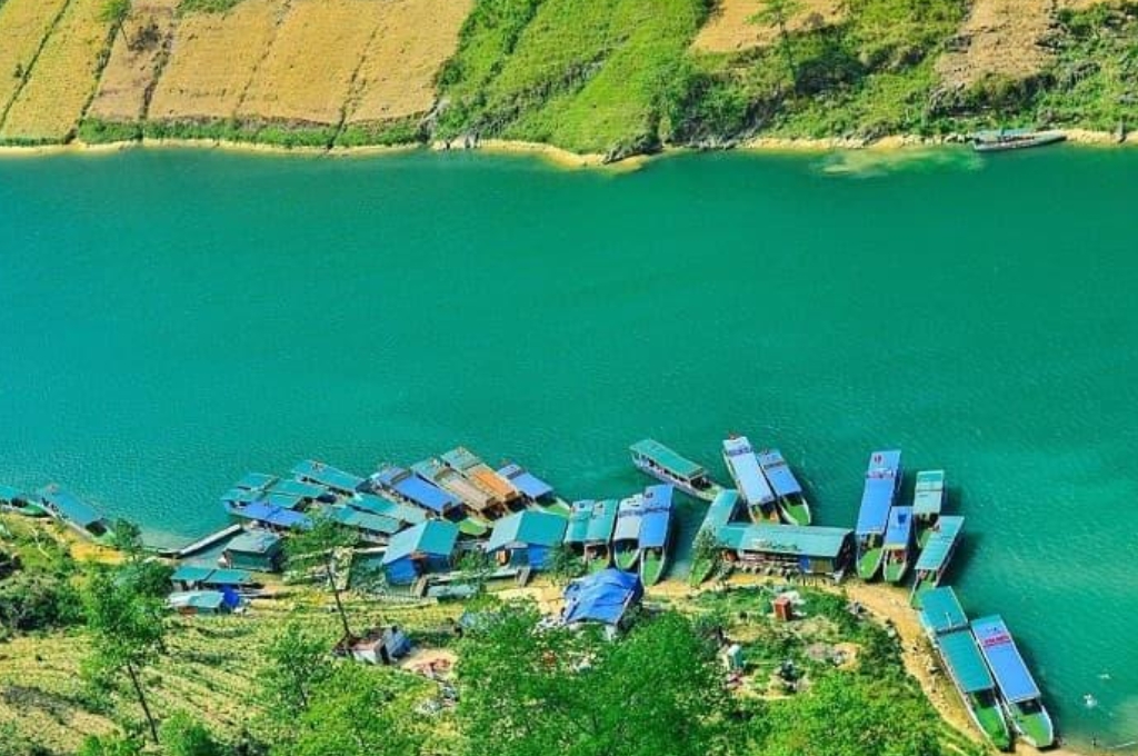 Khu vực bến thuyền trên sông Nho Quế với nhiều thuyền du lịch neo đậu sát chân núi.