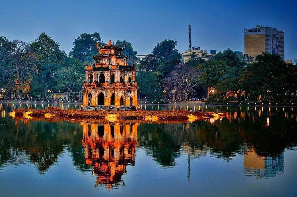 Tháp Rùa giữa Hồ Hoàn Kiếm Hà Nội phản chiếu trên mặt hồ vào buổi tối.
