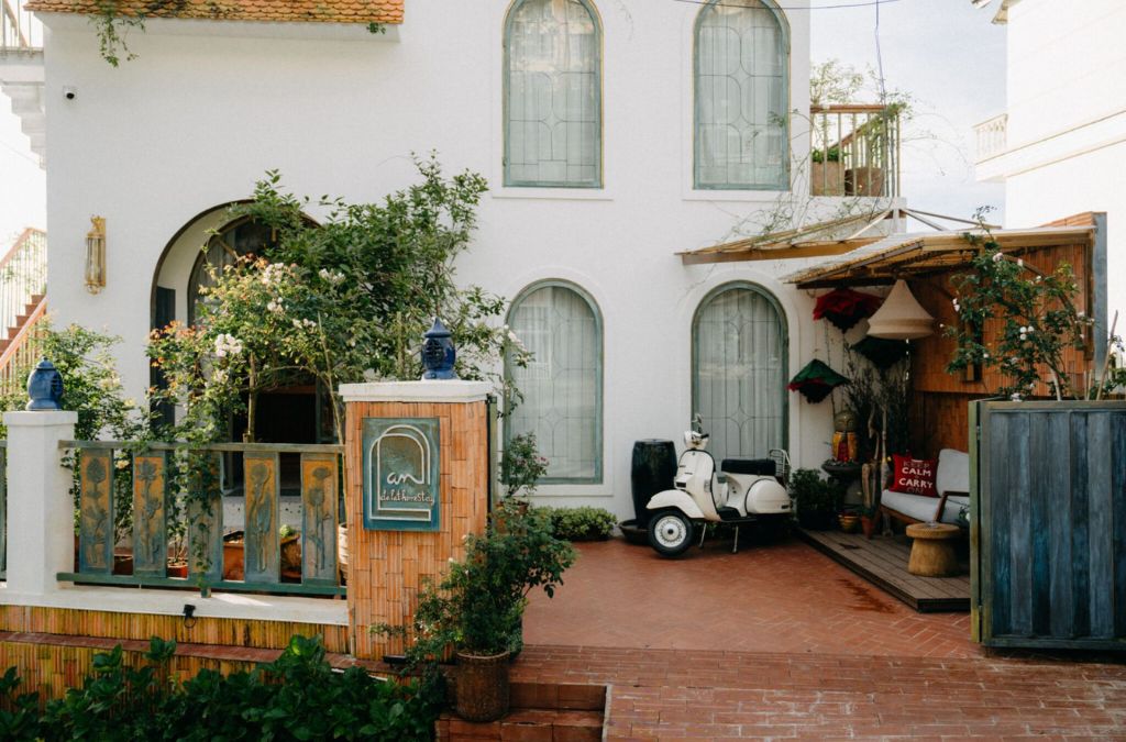 Mặt tiền Andalat Homestay với tường trắng và sân lát gạch