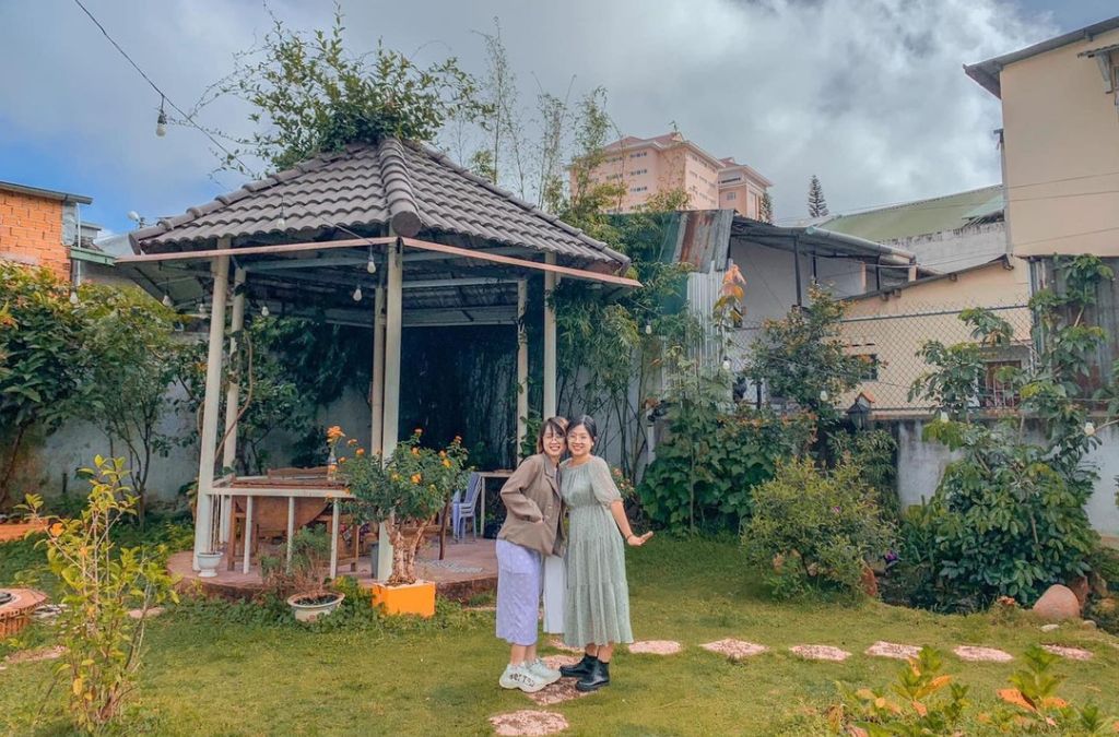 Hai người chụp ảnh trong sân vườn Xám Homestay Đà Lạt