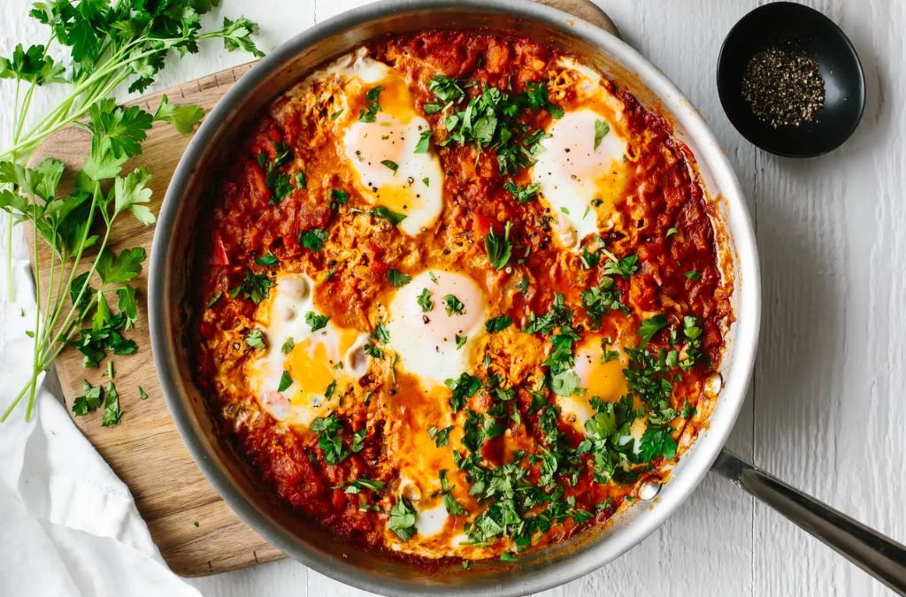 Chảo Shakshuka với trứng trong sốt cà chua và rau thơm