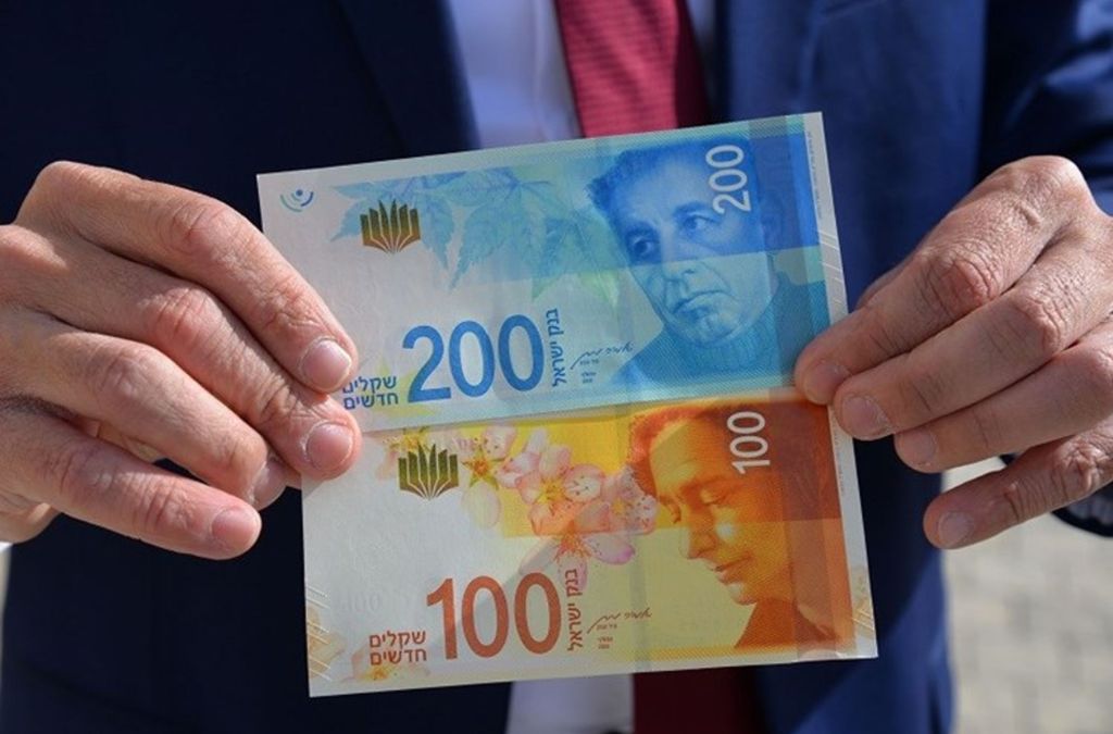 Tờ tiền 100 và 200 Shekel Israel được cầm trên tay
