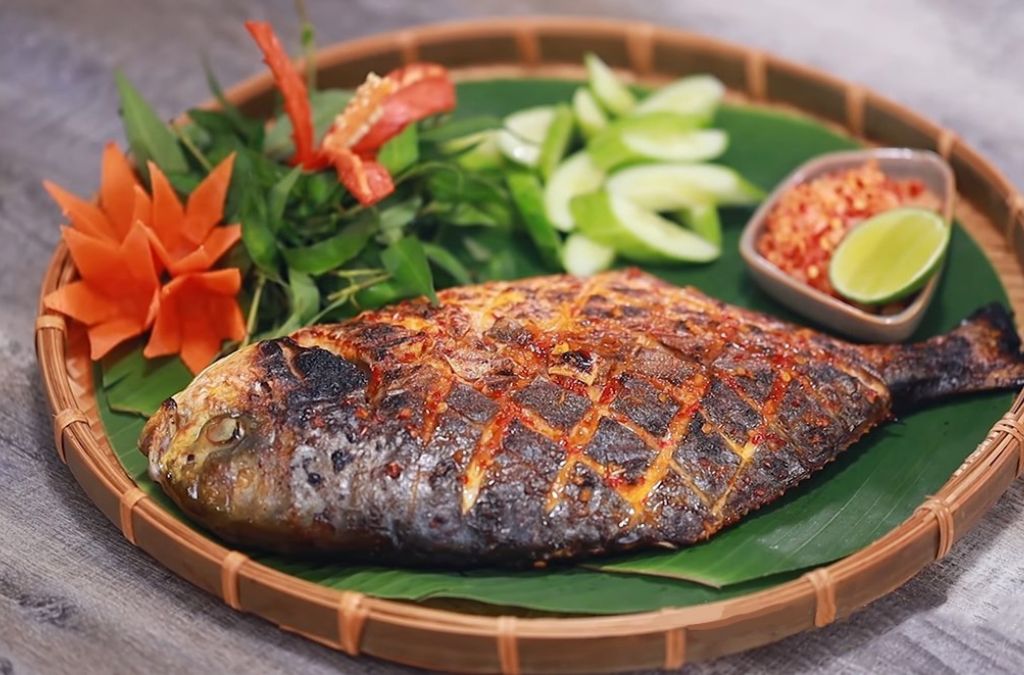 Cá biển nướng nguyên con ăn kèm rau sống và chấm muối ớt chanh