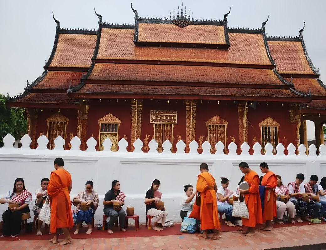 Các nhà sư đi khất thực trong ánh bình minh tại phố cổ Luang Prabang.