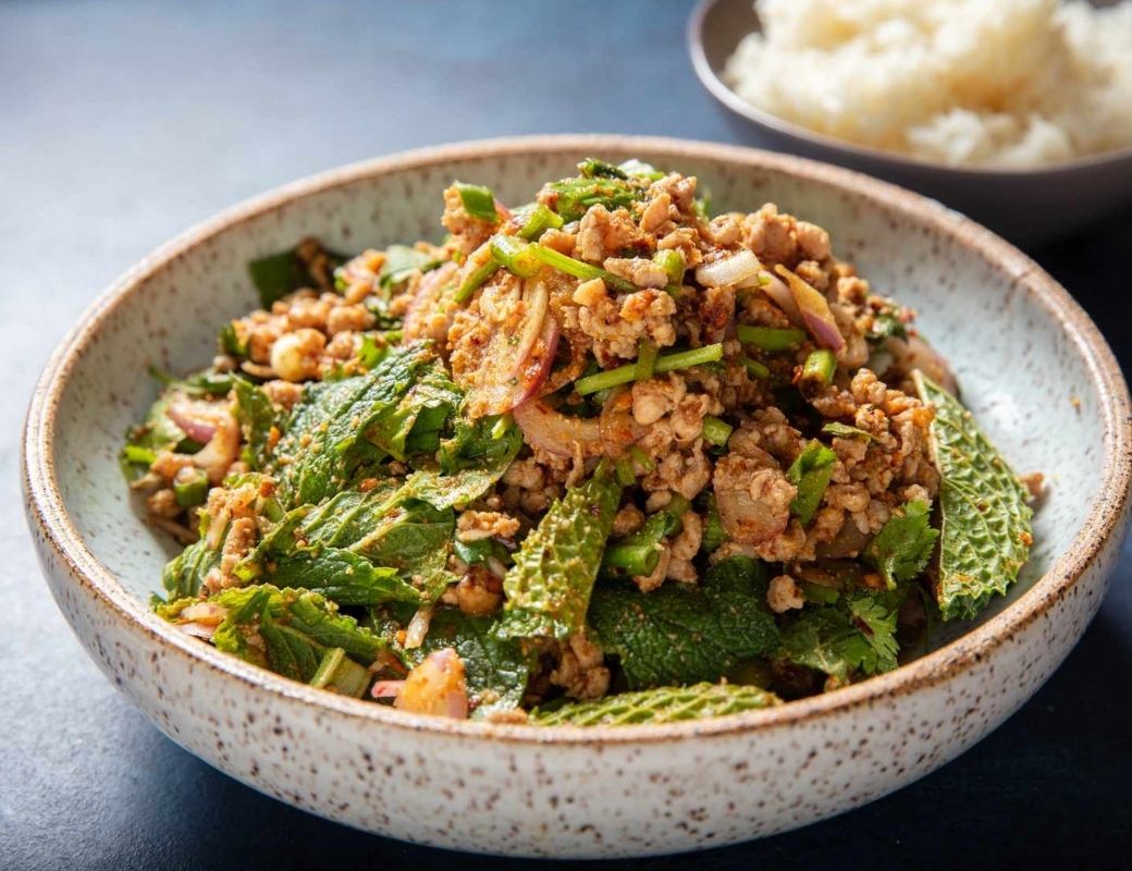 Đĩa gỏi thịt băm Larb ăn kèm rau thơm và gia vị Lào.