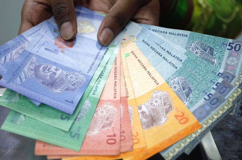 Các mệnh giá tiền Ringgit Malaysia được cầm trên tay