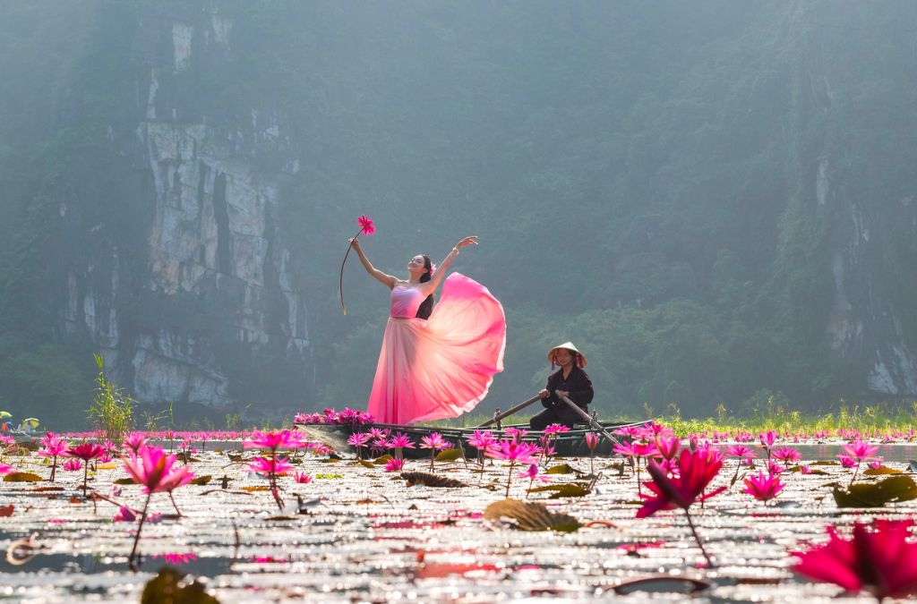 Người đang múa trên thuyền giữa hoa súng Ninh Bình