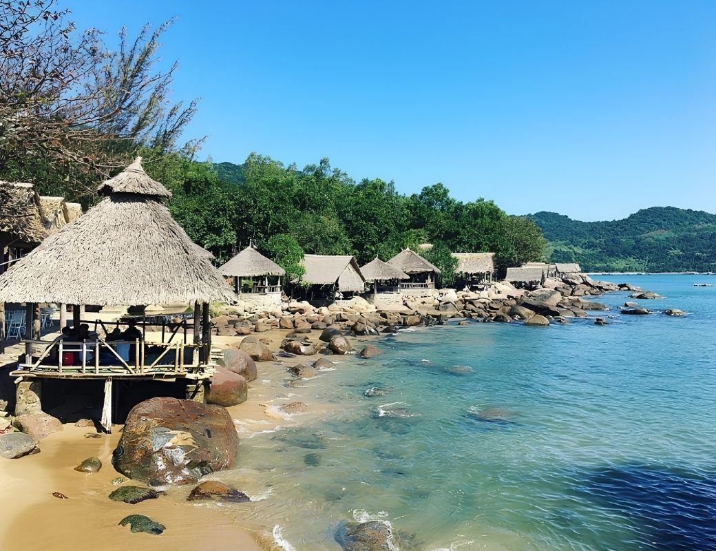 Bãi Rạng với biển xanh và hàng cây ven bờ.