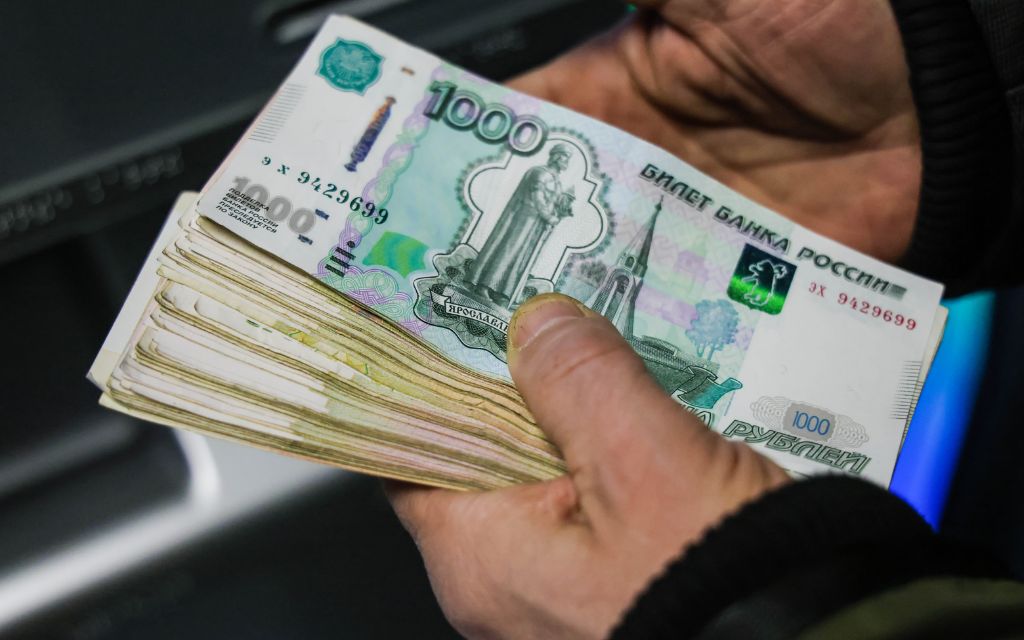 Người cầm nhiều tờ tiền Ruble Nga mệnh giá 1.000 RUB