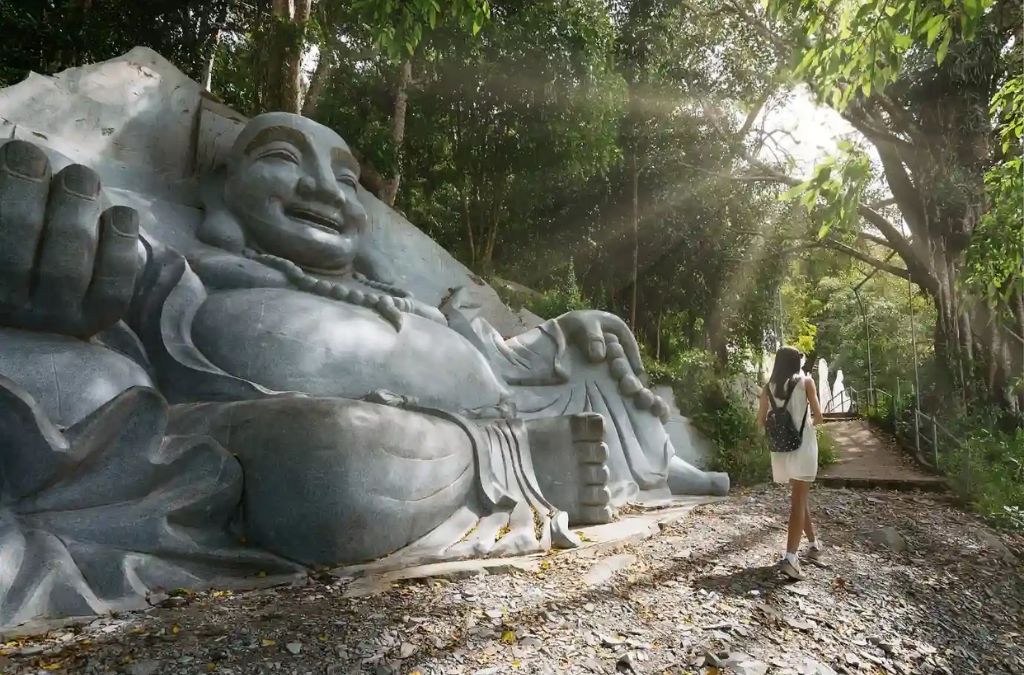 Người tham quan bên tượng Phật Di Lặc tại Núi Tà Cú