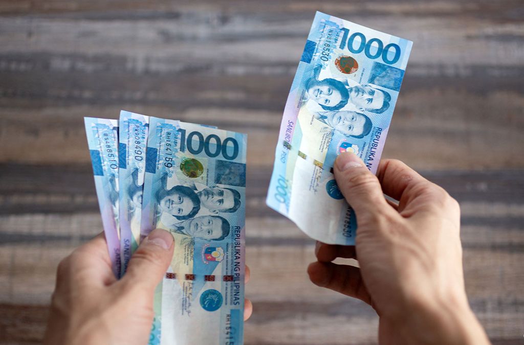 Người cầm các tờ tiền Peso Philippines mệnh giá 1.000 PHP