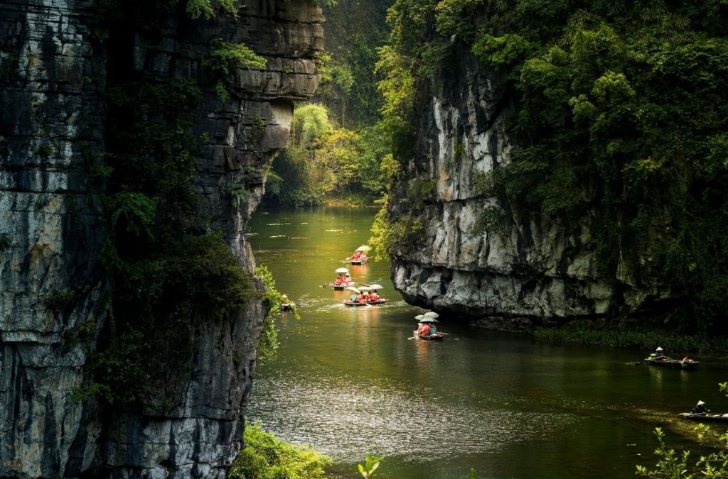 Thuyền tham quan Tràng An đi giữa những vách núi đá vôi
