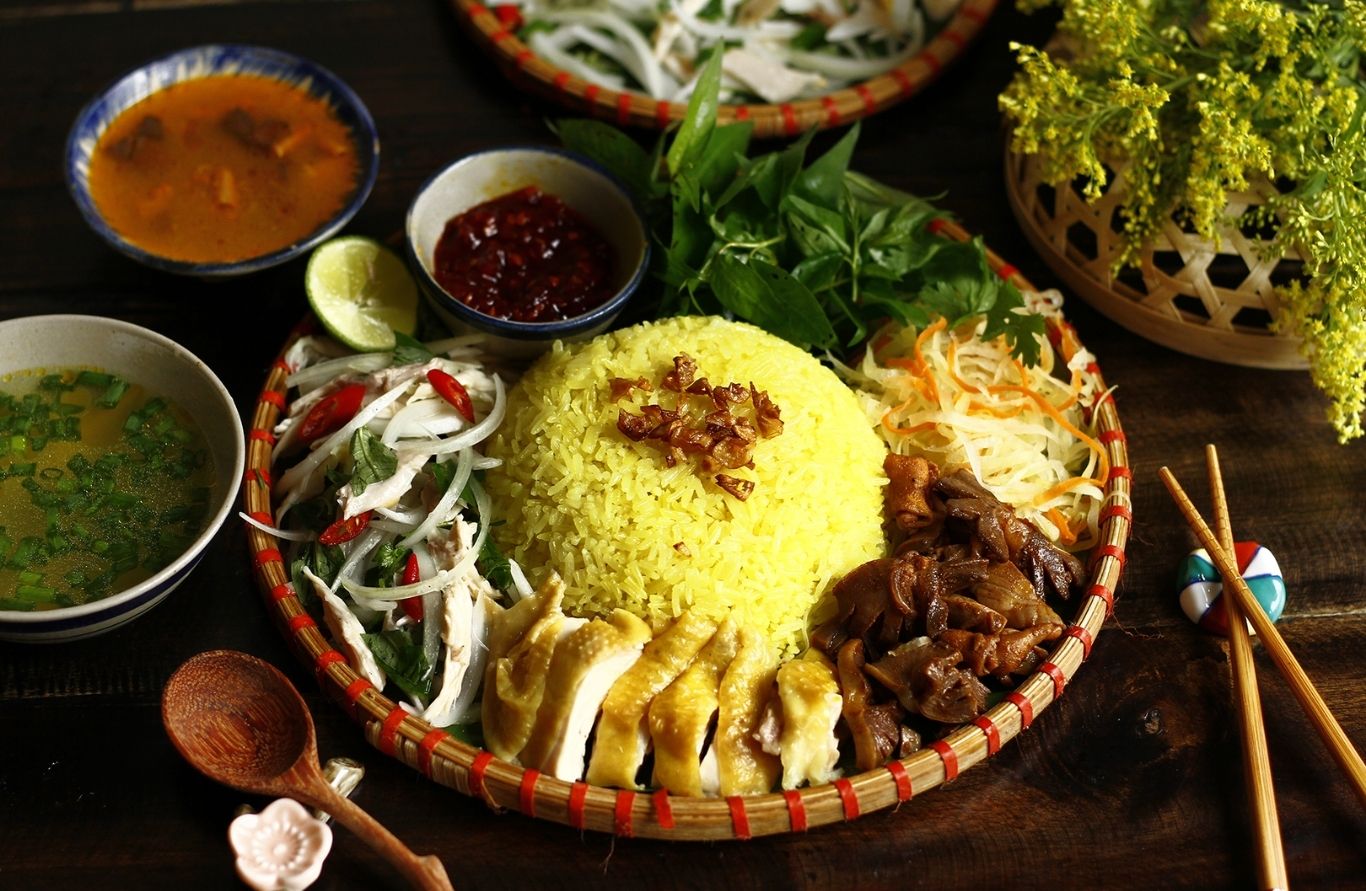 Đĩa cơm gà Hội An với cơm vàng, thịt gà xé, rau răm và nước chấm