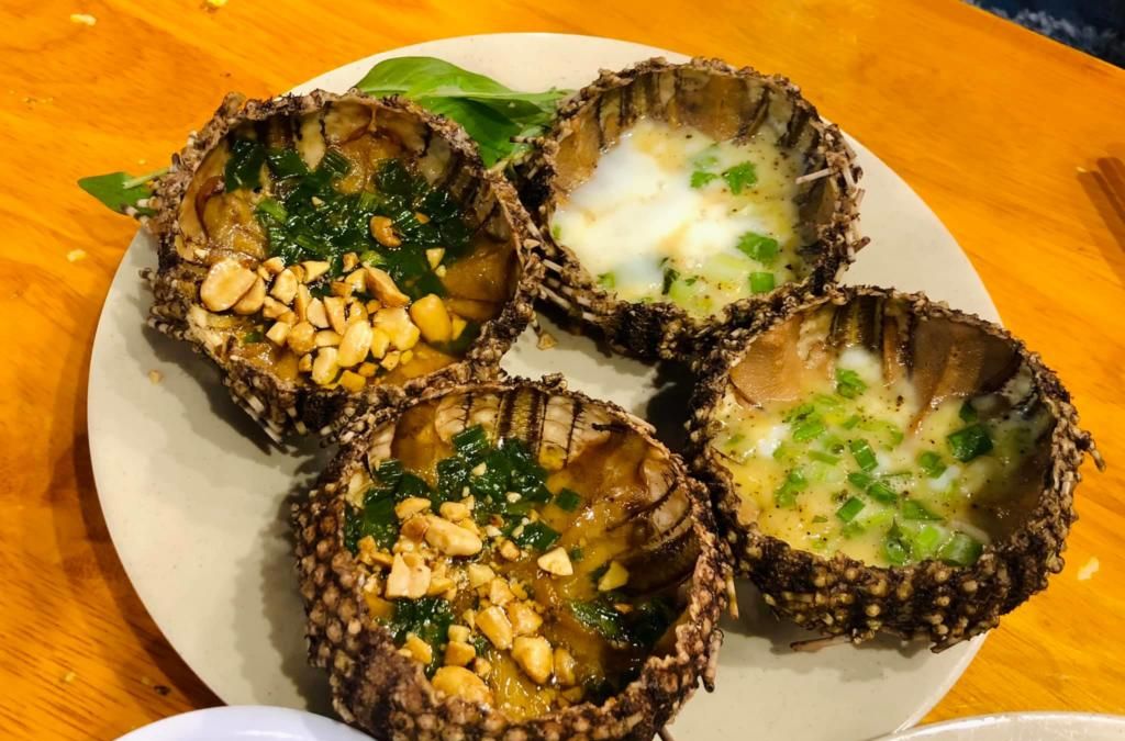 Những con nhum biển nướng mỡ hành và đậu phộng trên đĩa