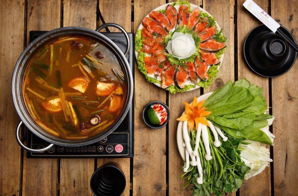 Lẩu cá hồi Sapa với cá hồi thái lát và rau xanh ăn kèm