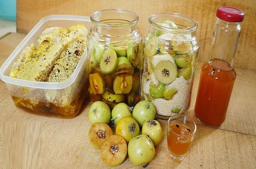 Rượu táo mèo ngâm trong hũ cùng những quả táo mèo tươi