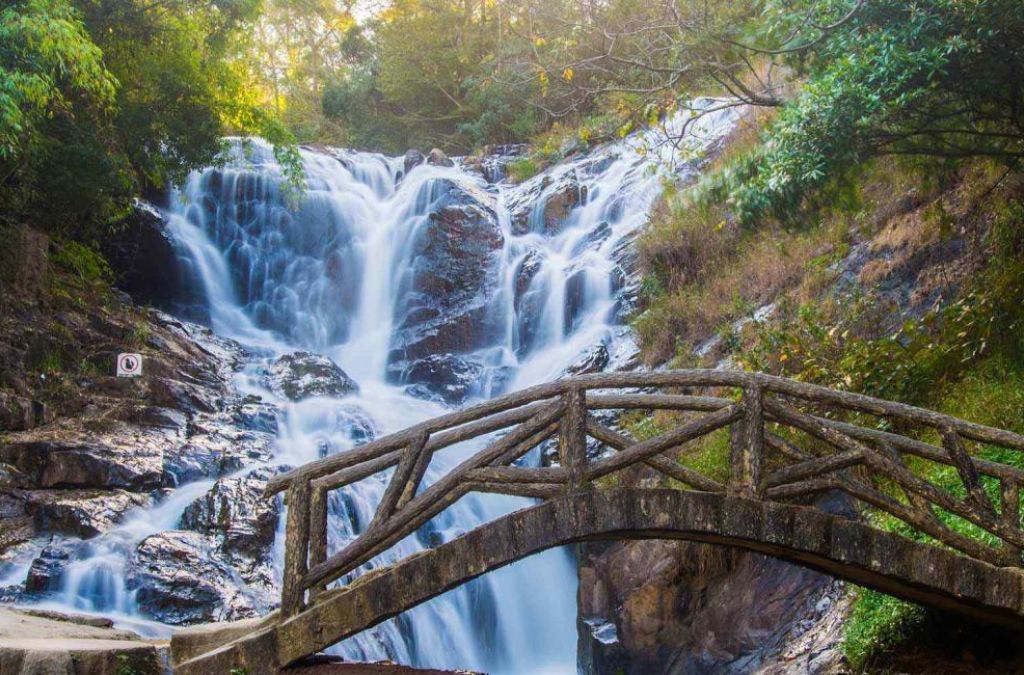 Thác Datanla đổ qua nhiều tầng đá phía sau cây cầu gỗ