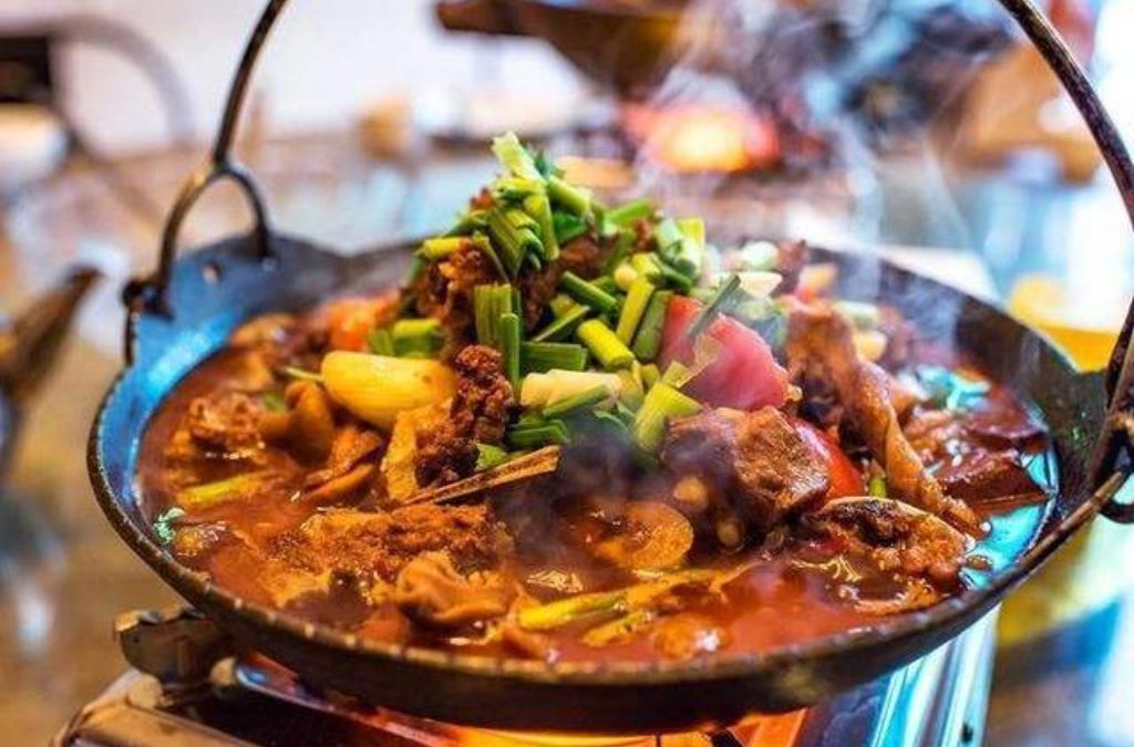Nồi Tam Hạ Oa với thịt, rau củ và ớt trong chảo gang